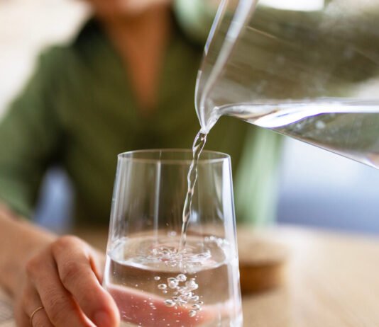 Hydration Hacks: How Much Water Do You Really Need? Jug of water pouring into glass