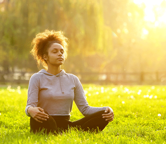 5-Minute Meditation Routines That Reduce Stress Fast Woman meditating on grass