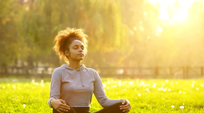 5-Minute Meditation Routines That Reduce Stress Fast Woman meditating on grass