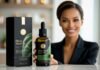 Black Seed Oil Benefits: Everything You Need to Know beautiful woman holding a bottle of black seed oil